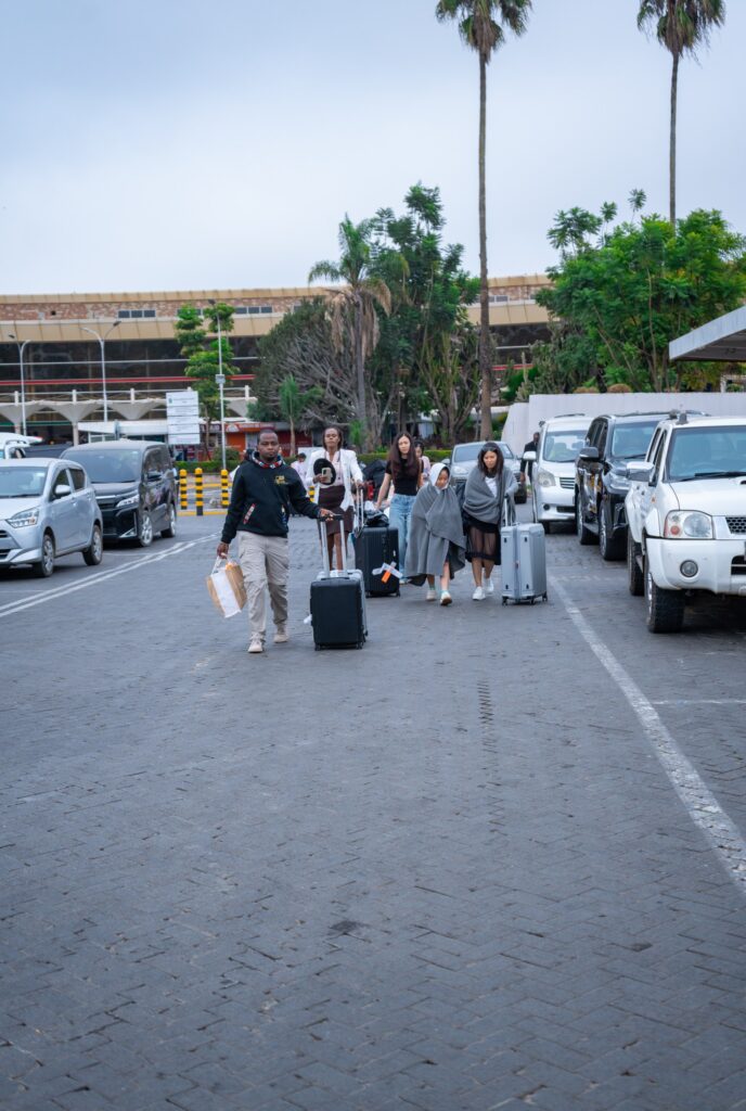 Afrikan Accent Adventures team assisting guests into transfer shuttle outside terminal following JKIA arrival.