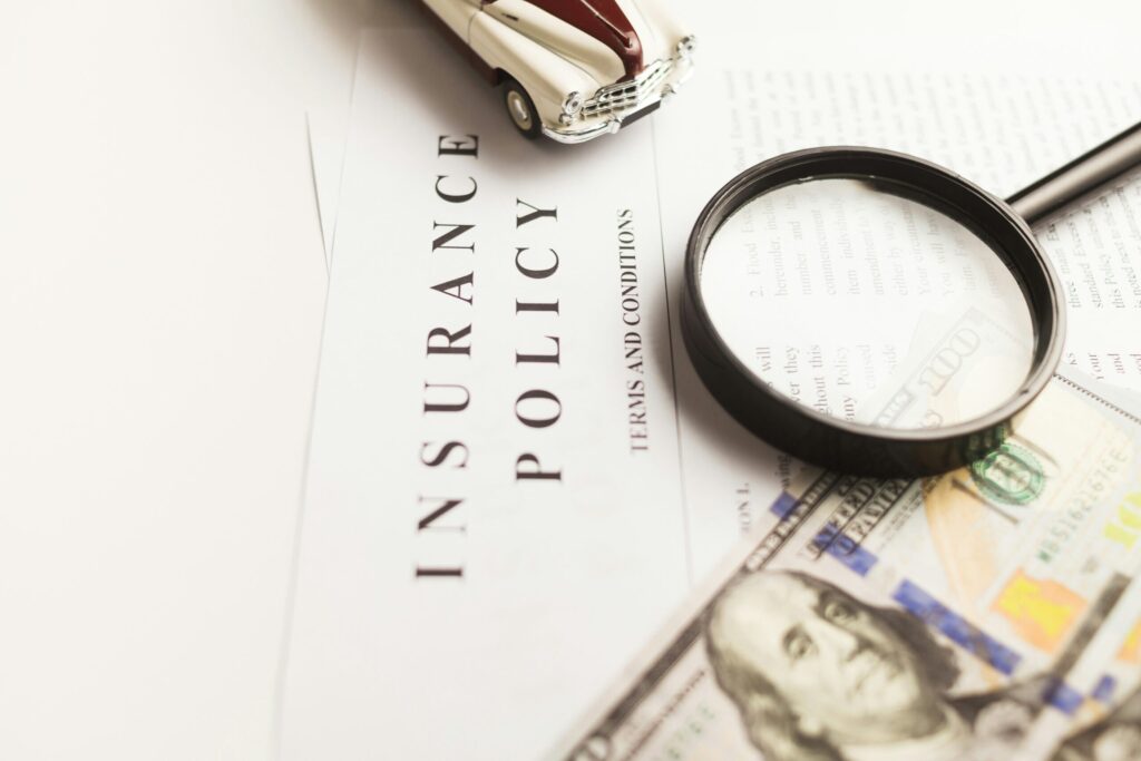 Magnifying glass over travel insurance policy fine print, highlighting safari-specific coverage gaps for Kenya safaris